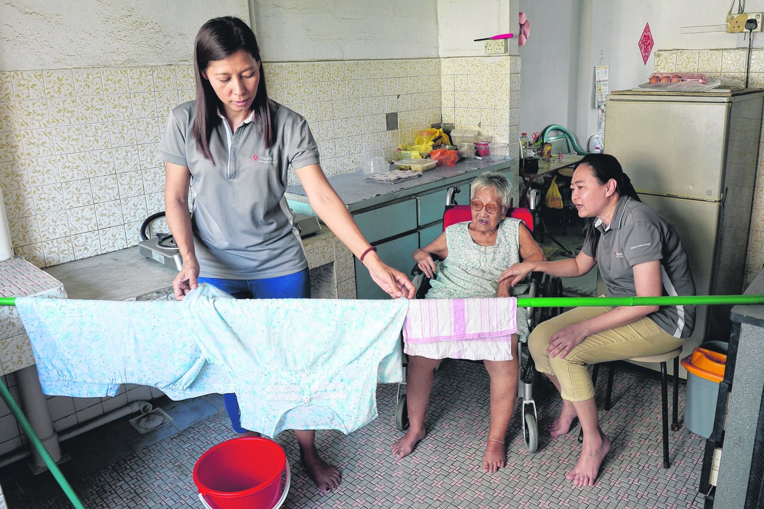 Staff from Touch Community Services helping Madam Chen, 92, with the housekeeping in her flat. Touch staff have regularly visited her since 2006. The Government is placing increasing emphasis on home-based care efforts in order to ease the demand on
