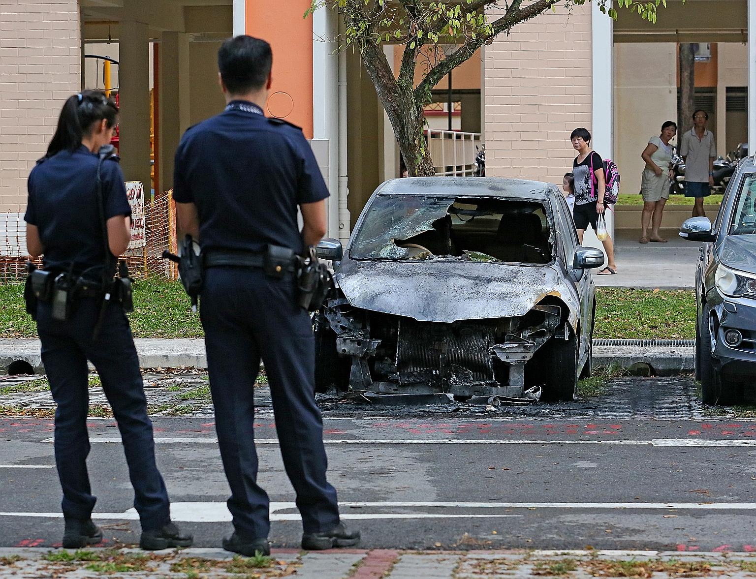 The car in the Ang Mo Kio carpark is reduced to a blackened heap. A fire broke out in its engine compartment on Tuesday afternoon. Residents nearby said they heard loud bangs as the car burned.