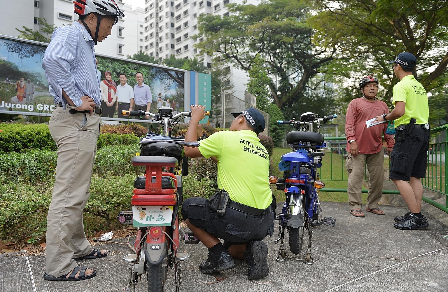 Members of LTA's Active Mobility Enforcement team inspecting motorised bicycles yesterday.