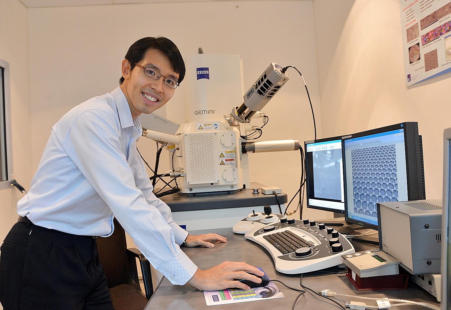 Dr Wong Liang Jie with a scanning electron microscope which the researchers use to check graphene for defects and to make sure it really is a single layer of atoms.