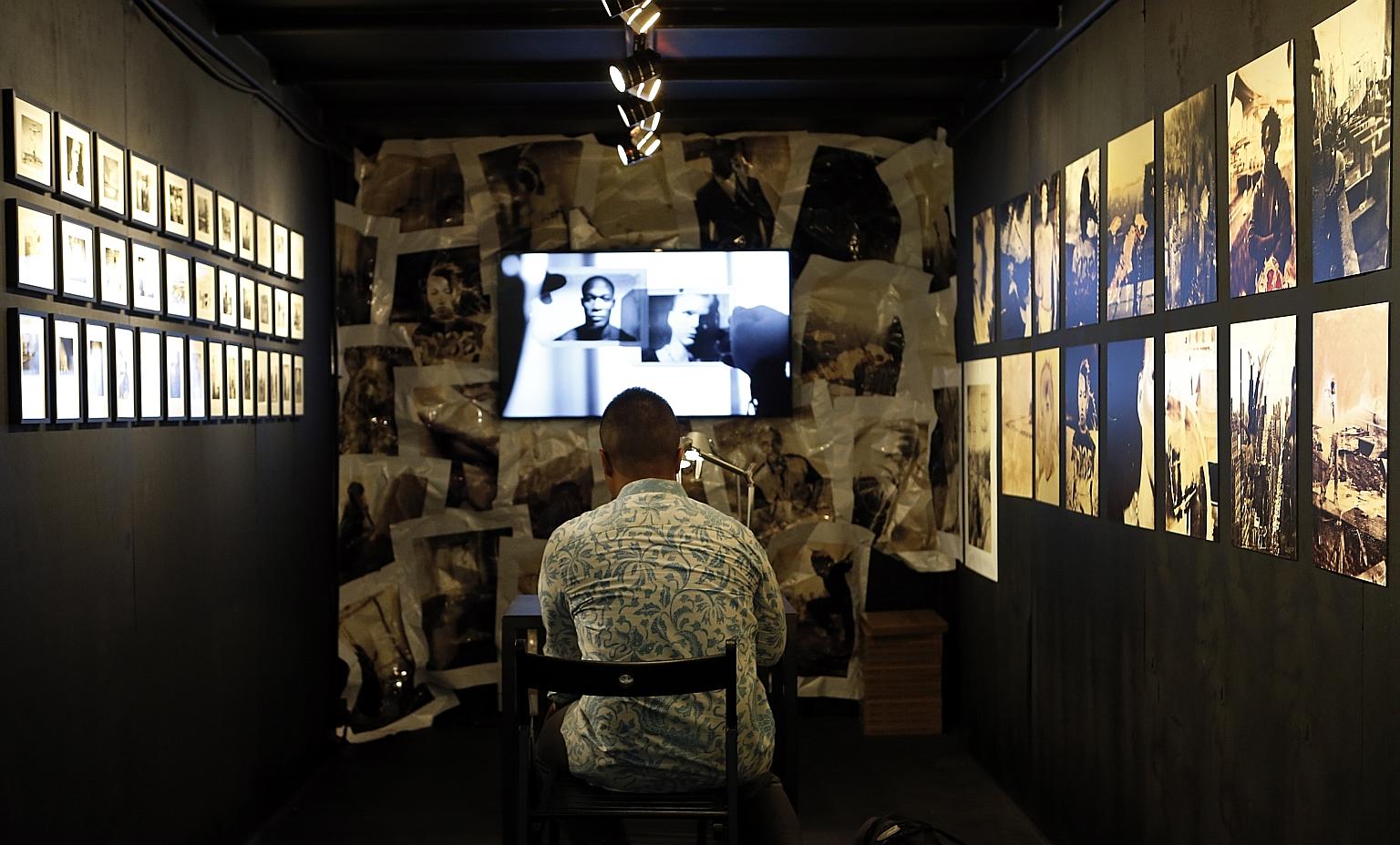 A visitor at the fifth Singapore International Photography Festival admiring Proof - a collection of contact proofs from photographic film - by award-winning Polish documentary film-maker and photographer Tomasz Gudzowaty. The work is part of the Arc