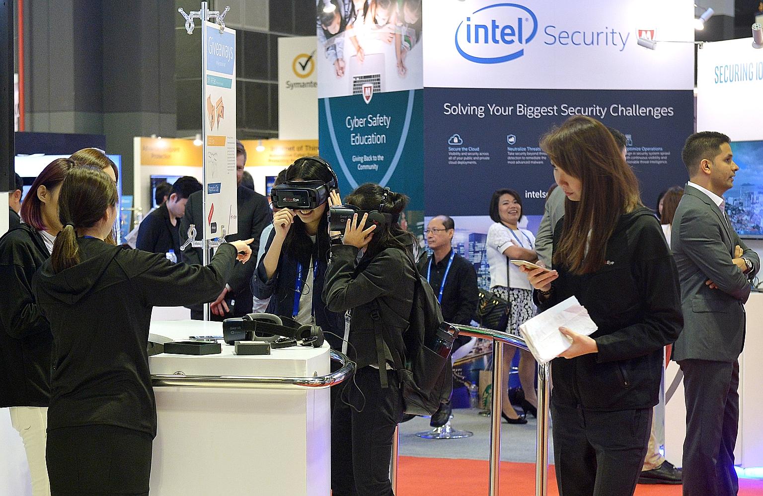 Visitors trying out virtual reality goggles at a booth at the inaugural Singapore International Cyber Week at Suntec Convention and Exhibition Centre yesterday.