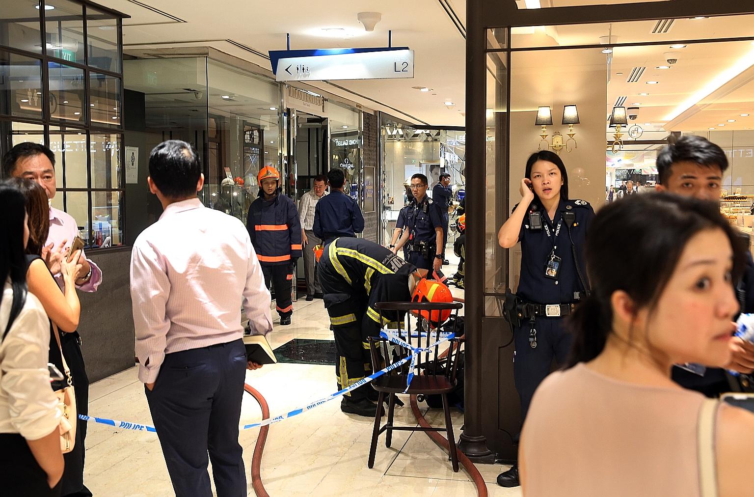 SCDF personnel and police officers outside Masterpiece Time & Jewels yesterday evening after a small fire broke out in the shop's ceiling. The police are investigating the cause of the fire.