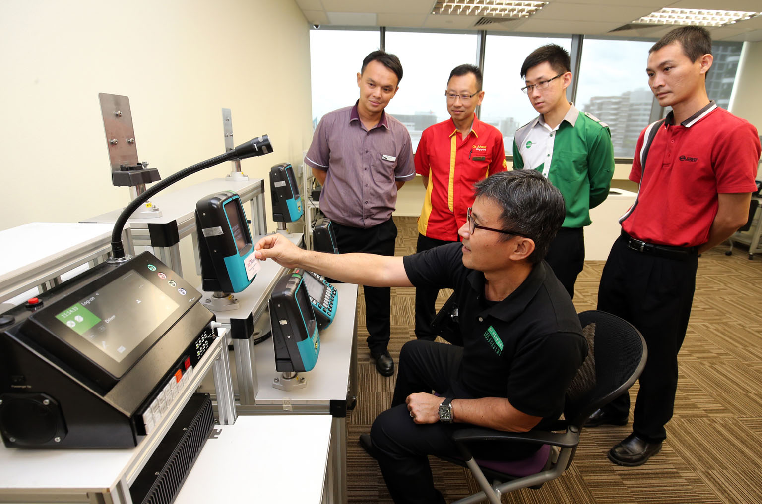 Singapore Bus Academy trainer Ho Hee Tock, 51, explaining the bus fare system to (from left) Mr Mok Kah Leong, 39, SBS trainee bus driver; Mr Yap Hong Hwi, 41, Go-Ahead bus driver; Mr Bernard Koh, 29, Tower Transit bus driver; and Mr Toh Swee Seng, 37, SM