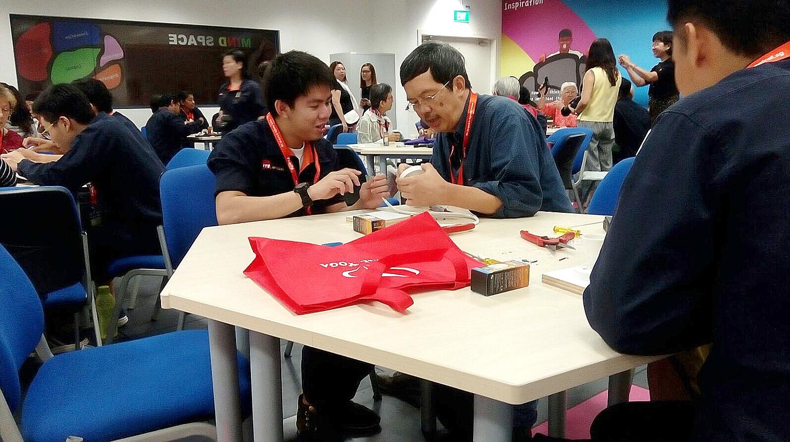 ITE student Marcus Leo and retiree Tom Toh building a table lamp at an Intergenerational Learning Programme course.
