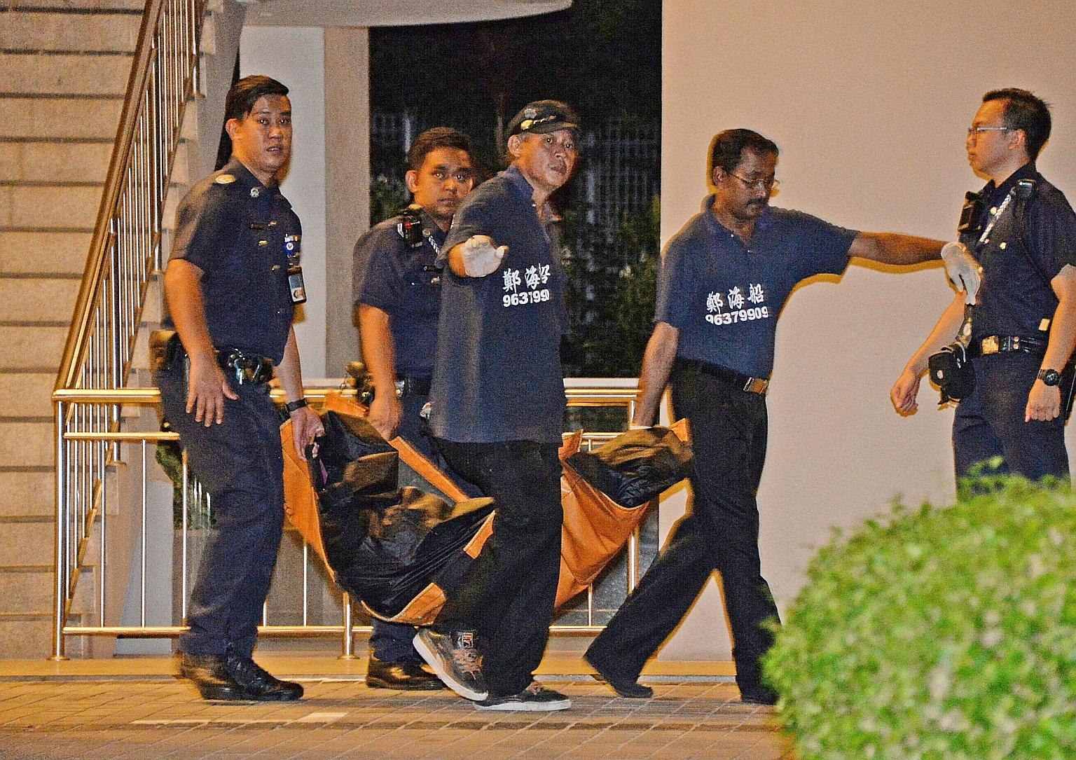 One of the bodies being removed early yesterday morning. After Mr Wang fell to his death, officers entered a 13th-floor unit and found Ms Ng's body in a bedroom. It is believed she had been stabbed.