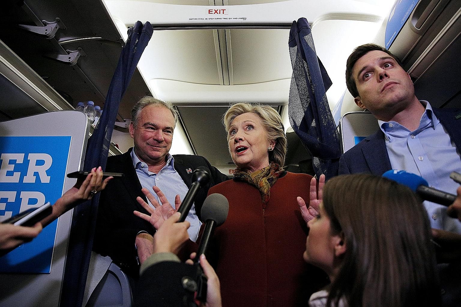 US Democratic presidential candidate Hillary Clinton and vice-presidential candidate Tim Kaine with the media inside a campaign plane. A recent poll showed that concern over media objectivity has spilled over to the public square.