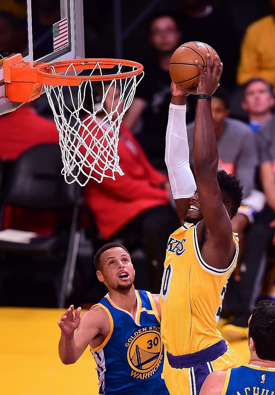 Stephen Curry of the Golden State Warriors can only watch as Julius Randle of the Los Angeles Lakers goes in for a dunk during their regular season game at the Staples Centre. The Lakers won 117-97, as Curry failed to make a three for the first time 