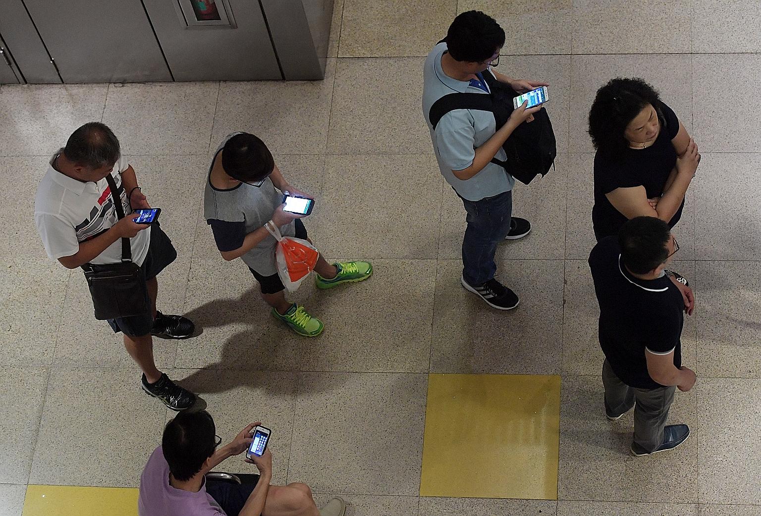 Commuters accessing mobile services on the Circle Line in Bishan station yesterday. Tests were done during the shutdown to isolate the cause of the signalling faults that have affected the line since Wednesday.