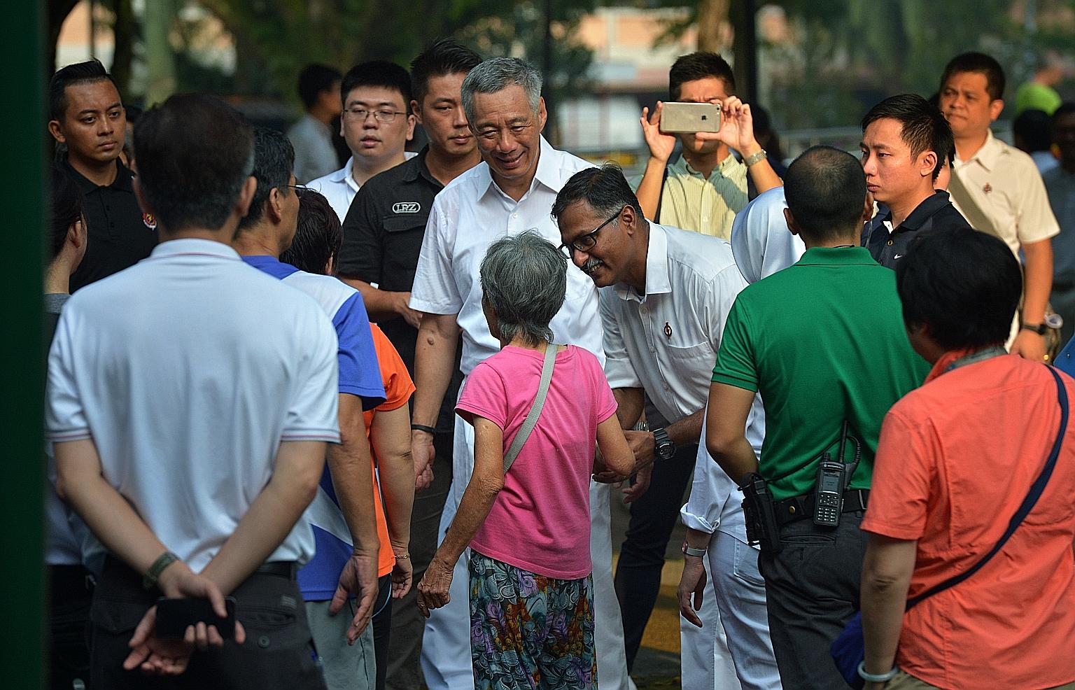 Mr Murali greeting an elderly resident at Bukit Batok Central Park while on a walkabout with PM Lee days before the by-election in May.