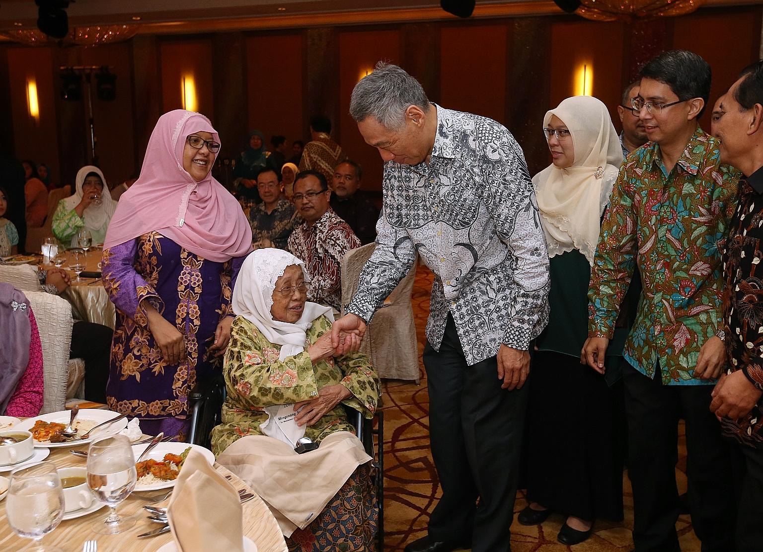 PM Lee presenting a token of appreciation to the late veteran writer Muhammad Ariff Ahmad's wife Sarinah Haniff as her daughter Shahrulbariah (left) looks on at the Arif Budiman Malay Language Teachers' Award ceremony yesterday. Behind PM Lee are Ang