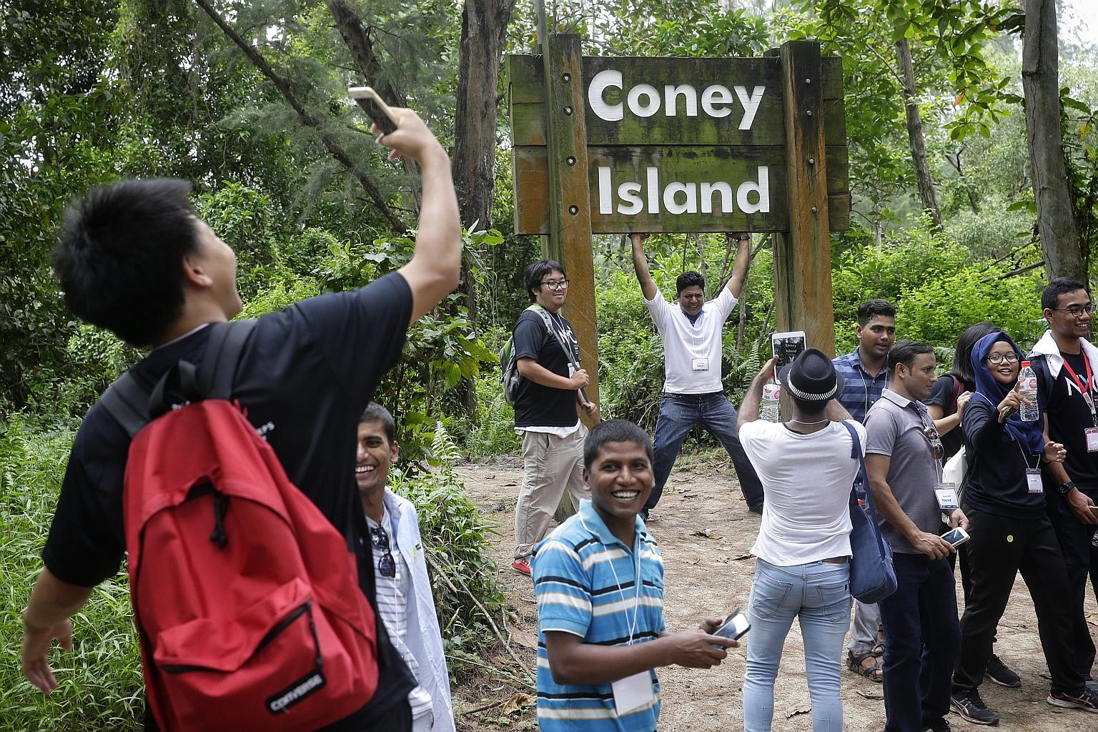 Bangladeshi worker Nasir (who goes by one name), a 41-year-old who works as an assistant supervisor in a shipyard, posing for photographs under the Coney Island signboard during a walk yesterday. The event was organised by some young people from Outw