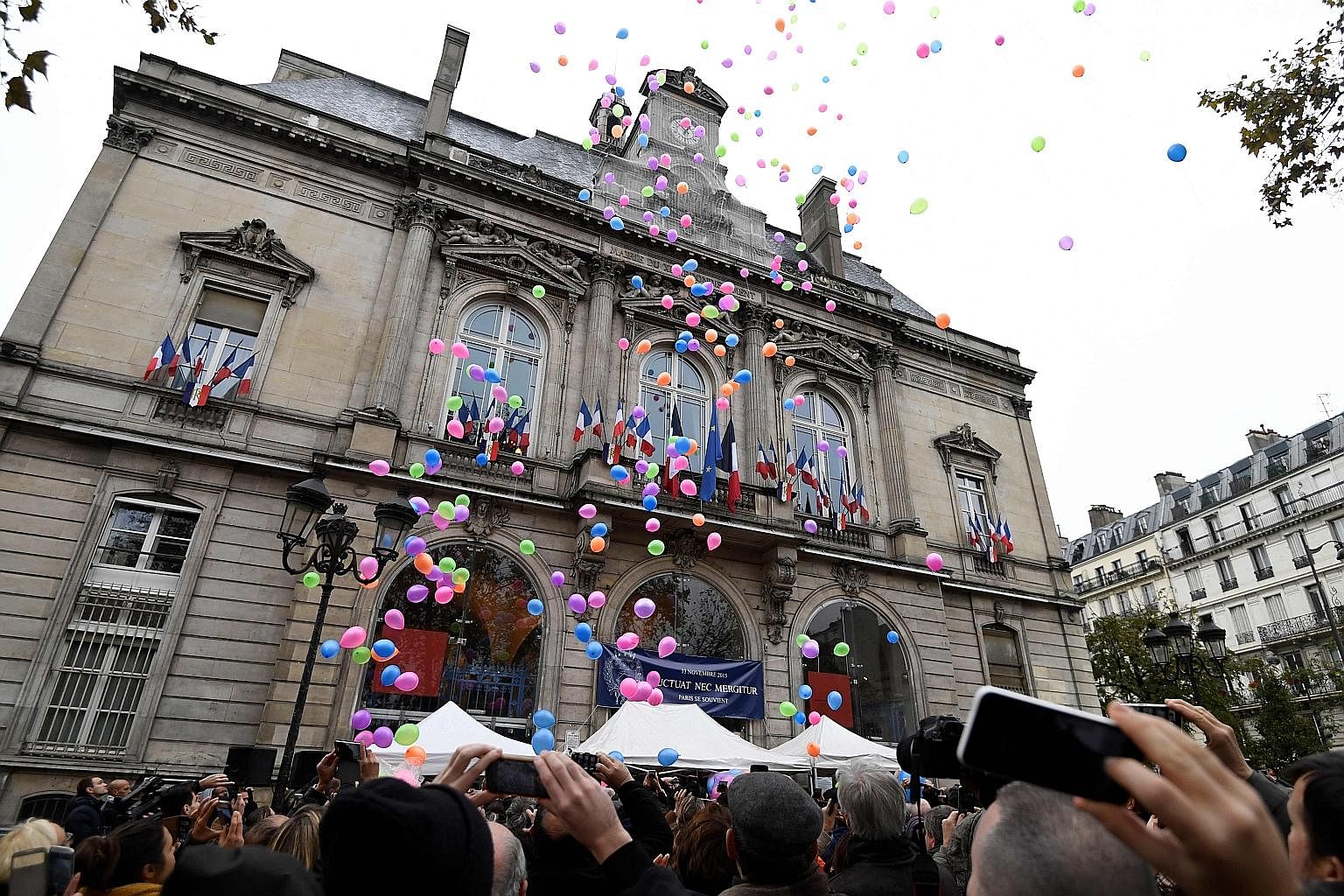To mark the first anniversary of the Nov 13 terrorist attacks in Paris, people released balloons (above) in front of the city hall of Paris' 11th arrondissement yesterday while Sting (below) played a day earlier at the reopening of the Bataclan conce