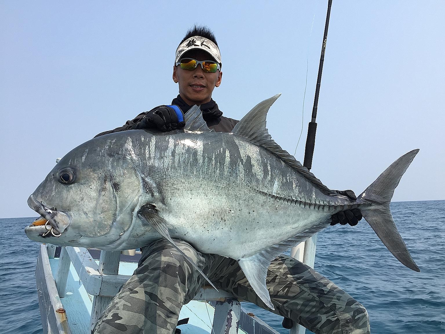 Mr Ivan Goh, chief guide of Deep Sea Fishing, with a giant trevally caught last year in East Kalimantan, Indonesia. He said the company has stopped making trips to Indonesian waters where the anglers were arrested as a "precaution".