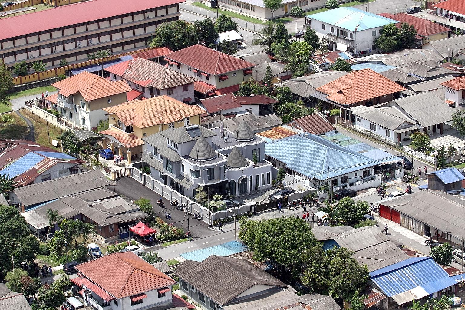 Malaysian PKR Youth chief Adam Rosly (above) owns a bungalow, worth S$2.26 million according to his detractors. The house (right), with its three conical roofs, stands out among the humbler structures in the Malay urban kampung enclave of Ampang.