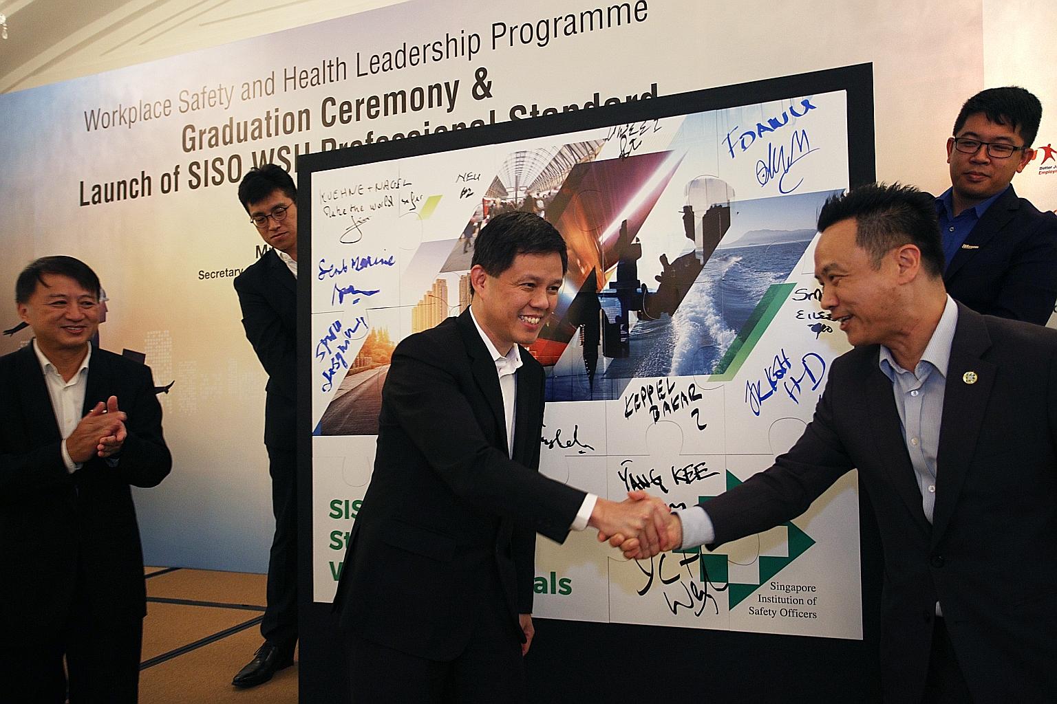 Labour chief Chan Chun Sing (centre) congratulating SISO president Bernard Soh after the launch of the new standard. With them is Mr Ho Siong Hin, Commissioner for Workplace Safety and Health.