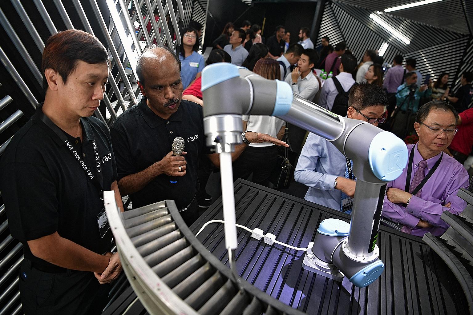 e2i CEO Gilbert Tan (left) taking a look at a compound remover with Race trainer A. S. Sundaram yesterday.