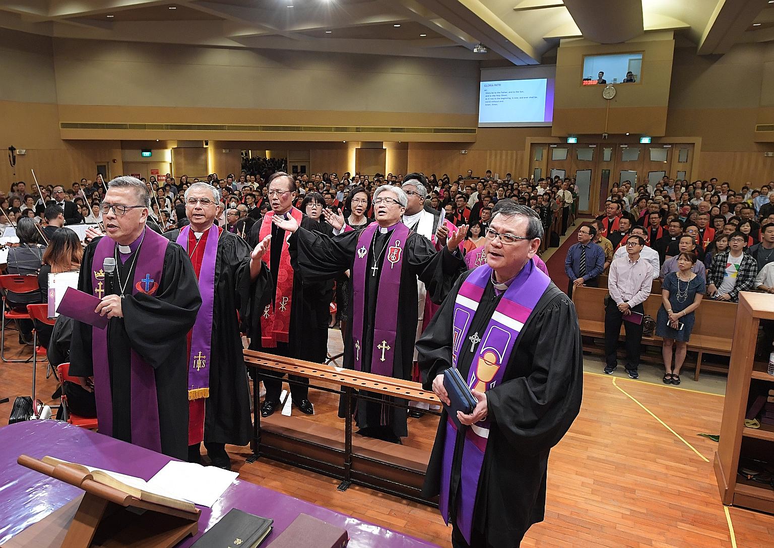 With Dr Chong (with arms outstretched) at his consecration service yesterday were (from left) Bishop Emeritus Dr Wee; Dr James Kwang, bishop of the Chinese Methodist Church in Australia; Bishop Chen Chien Chung of the Methodist Church in Taiwan; and