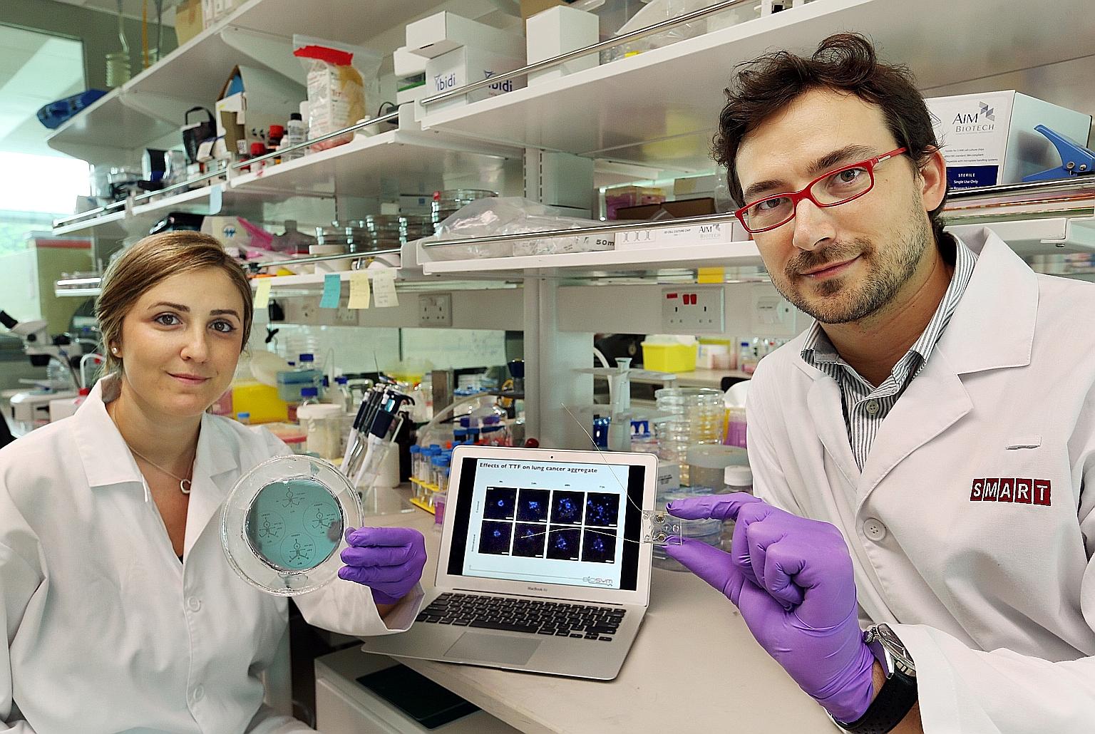 The device between Dr Pavesi's fingertips is no larger than a stamp but he hopes to use it to explore electric fields and cancer cells. Team member Giulia Adriani is holding the mould used to make the tool.
