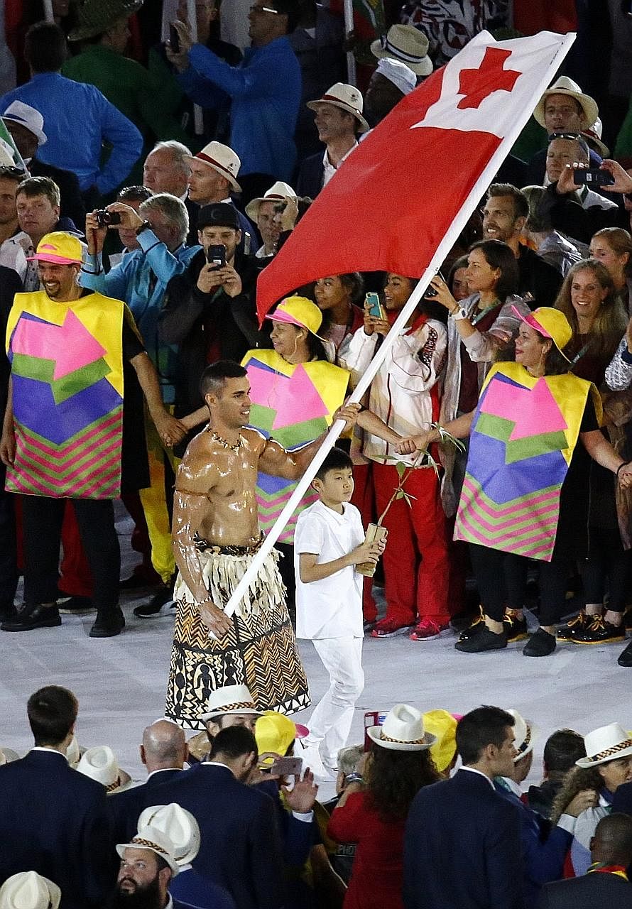 Left: Tonga's flag-bearer Pita Taufatofua, who stole the limelight at the Rio Olympics opening ceremony, plans to compete at the 2018 Winter Olympics as a cross-country skier. Above: Taufatofua straps on skis at Bear Mountain, California, during the 