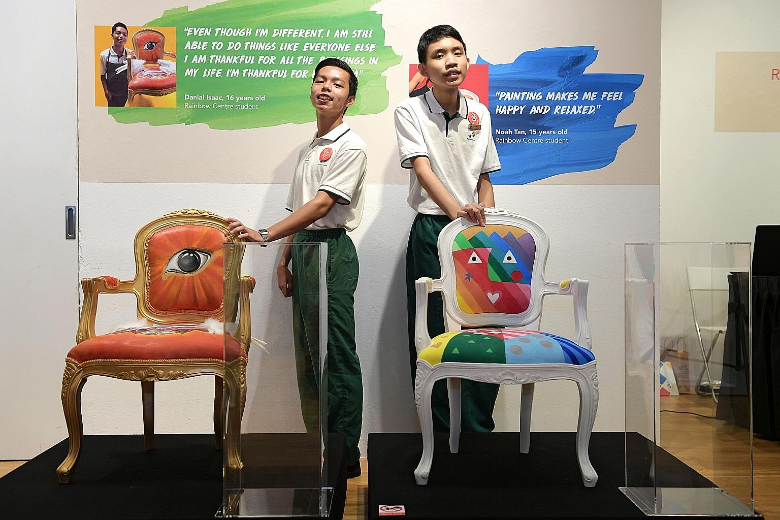 Rainbow Centre students Danial Isaac (at left) and Noah Tan with their chairs at Ion Orchard yesterday. The chairs, painted by them, were auctioned for nearly $50,000, and the funds will go towards a new wing at the special needs school's Margaret Dr