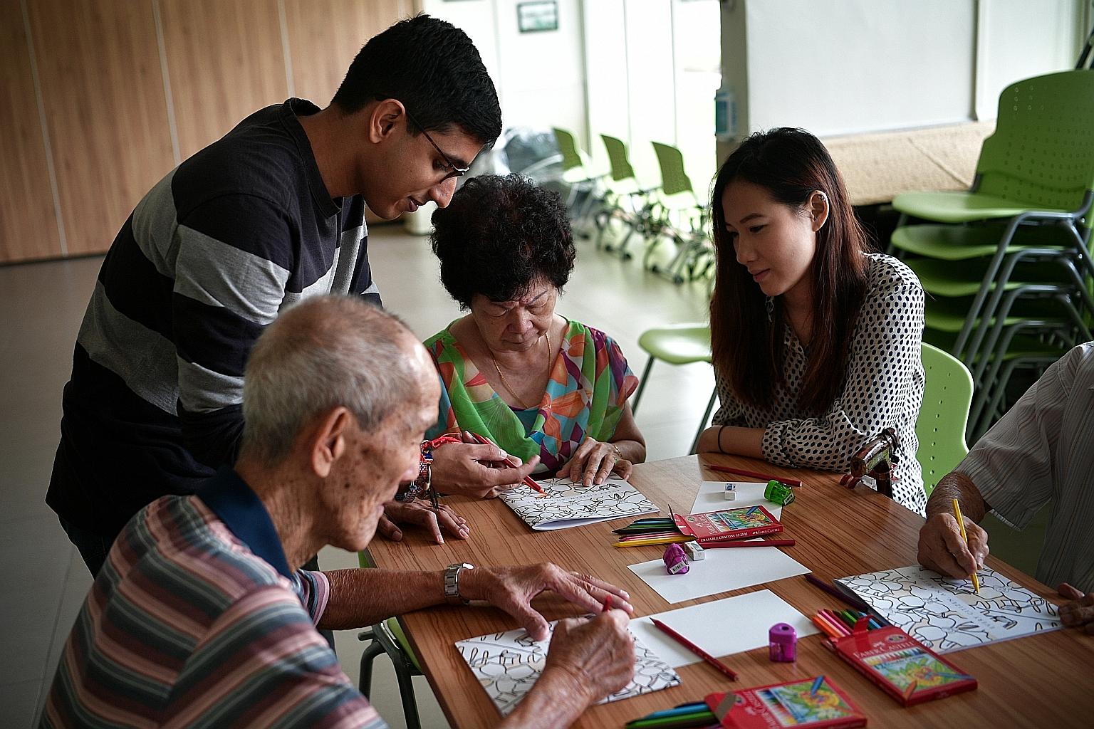 Mr Upadhiah and Ms Tan with Madam Lam and other participants of the inter-generational book project at St Luke's ElderCare Clementi Centre last week.