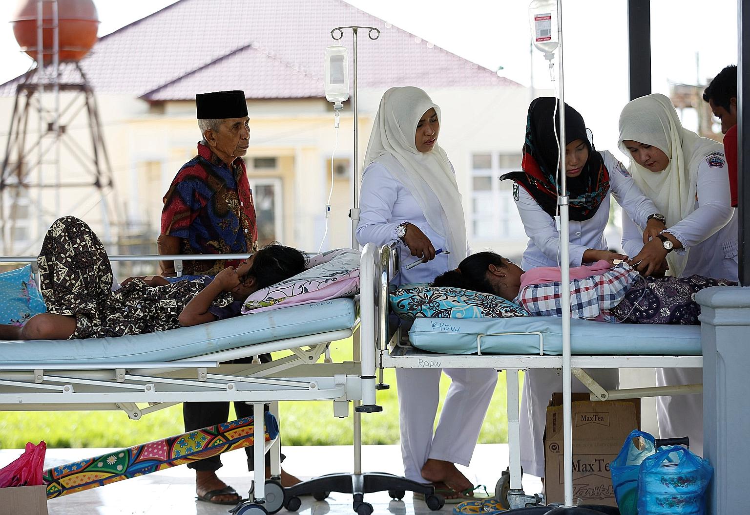 Earthquake victims being attended to outside a hospital in Meureudu, Pidie Jaya, in Aceh province yesterday. The Indonesian Embassy in Singapore says it has received many queries from people who want to help.