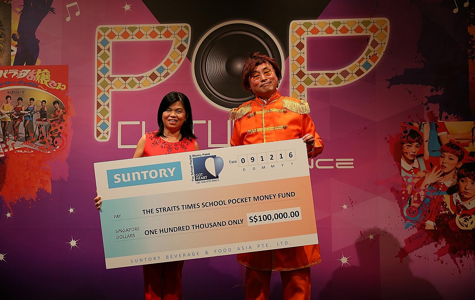 Ms Tan Bee Heong, general manager of The Straits Times School Pocket Money Fund, receiving a cheque for $100,000 from Mr Kazuhiro Saito, chief executive officer of Suntory Beverage & Food Asia, at the company's Pop Culture Dinner and Dance yesterday.