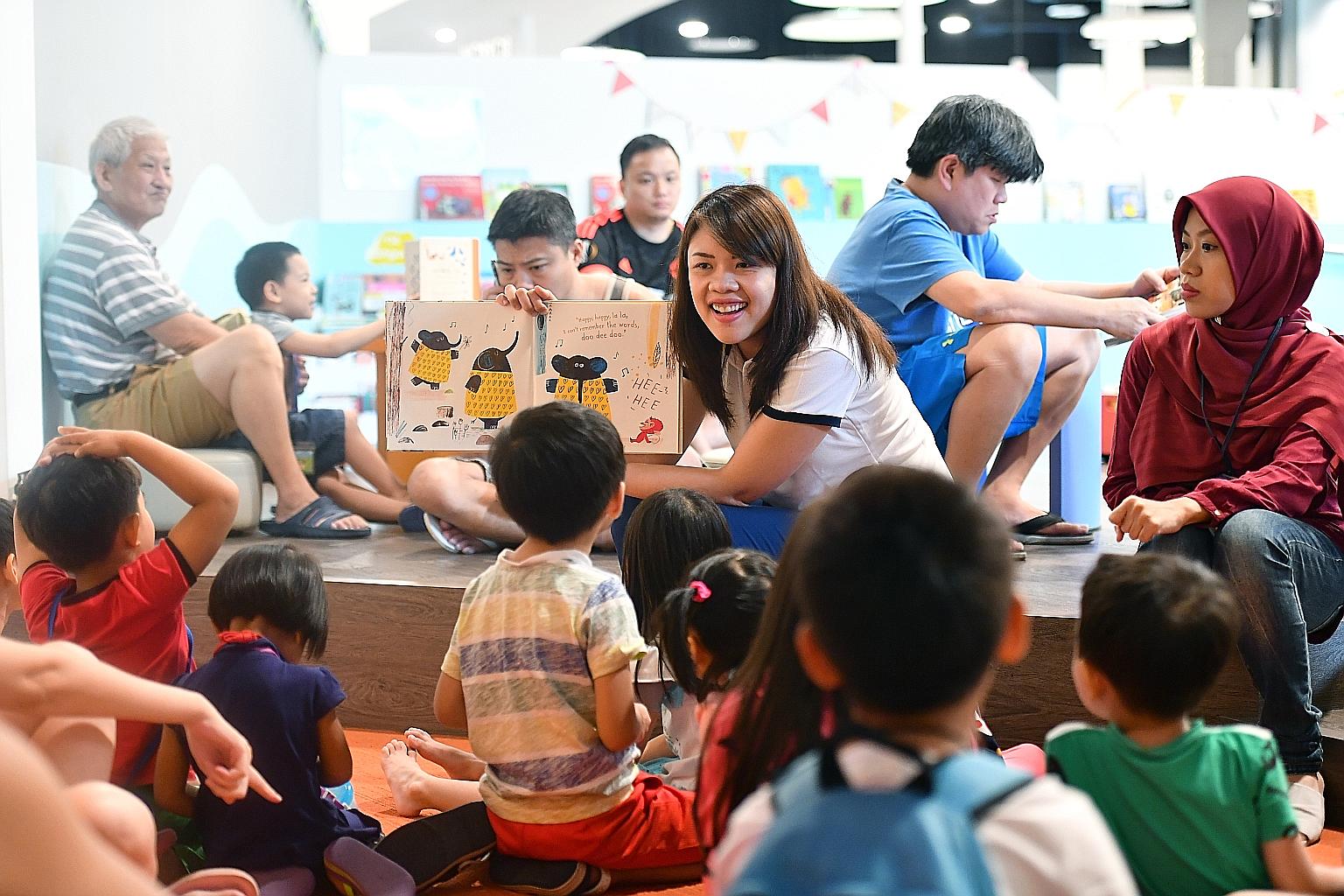 Mrs Davy Natividad, a quality manager at POSB, reading a tale about a forgetful elephant and its friend to about 15 children at Pasir Ris Public Library yesterday. It was the 36-year-old's first time reading a storybook to children. She was trained a