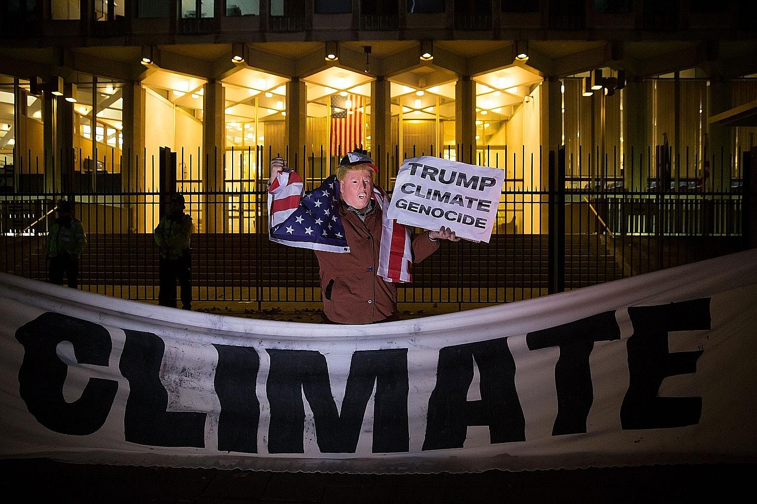A man wearing a Trump mask protesting against the US President-elect's vow to pull the US out of the Paris deal outside the US Embassy in London last month.