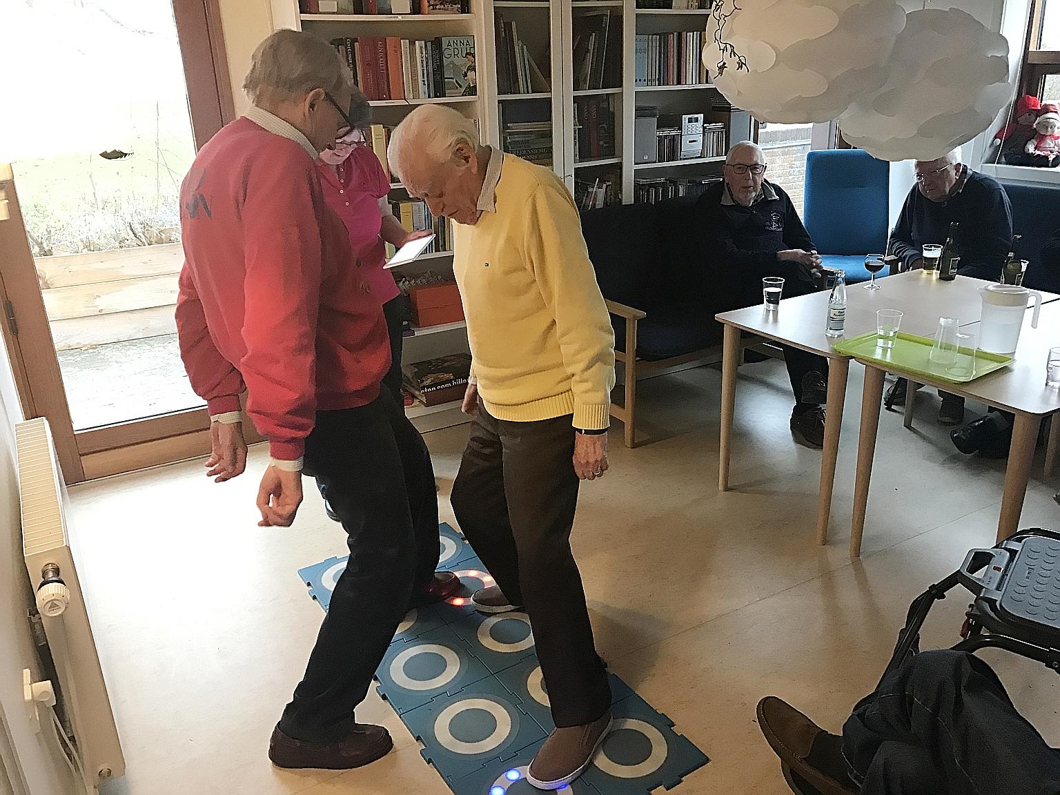 This rehabilitative game makes use of interactive tiles to help seniors (from left) Hans Joergen and Bendt Fogh improve their balance and reflexes while having a fun workout at the Vennerslund Day Centre.