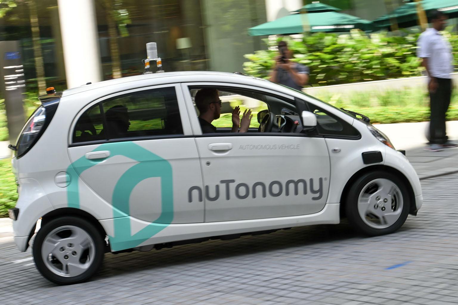 A safety driver demonstrating a driverless car during a public trial run here in September. The question of who is to blame in an accident involving an autonomous vehicle remains a sticking point here.
