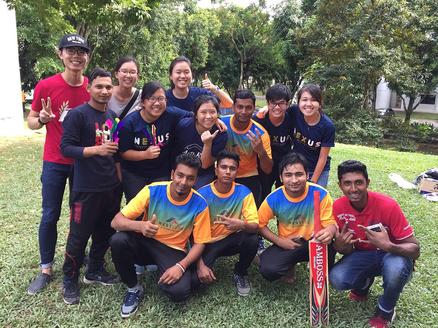 Students from the NUS College of Alice and Peter Tan with migrant workers from India and Bangladesh after a cricket match on Dec 4. The workers, who enjoyed a rousing game and a carefree day out in the sun, also got their blood pressure measured.