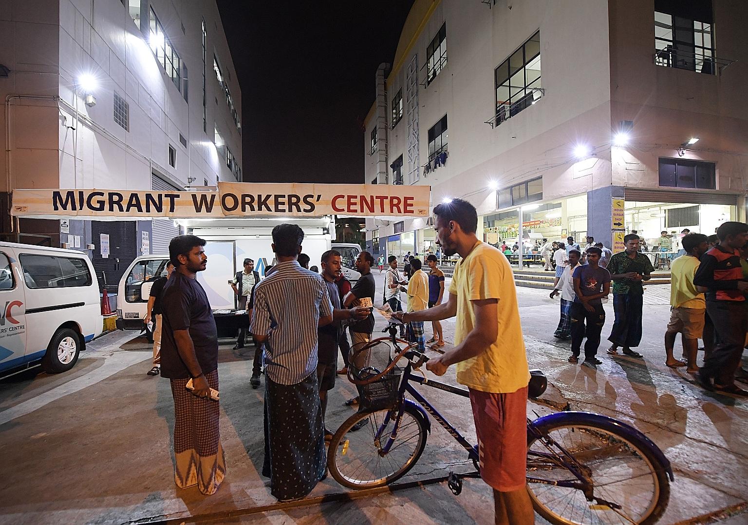 Mr Raja Ramasamy Raj (third from left), 39, and Mr Jeyabal Simeon (left), 32, both volunteers with the Migrant Workers' Centre, talking to migrant workers in Tuas View Square. The centre has conducted outreach to more than 650,000 foreign workers sin