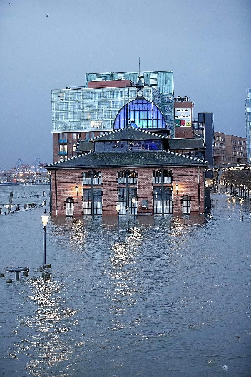 The historic Fish Auction Hall in Hamburg was immersed in knee-deep waters yesterday as the storm brought heavy winds, flooding and snowfall across the country.