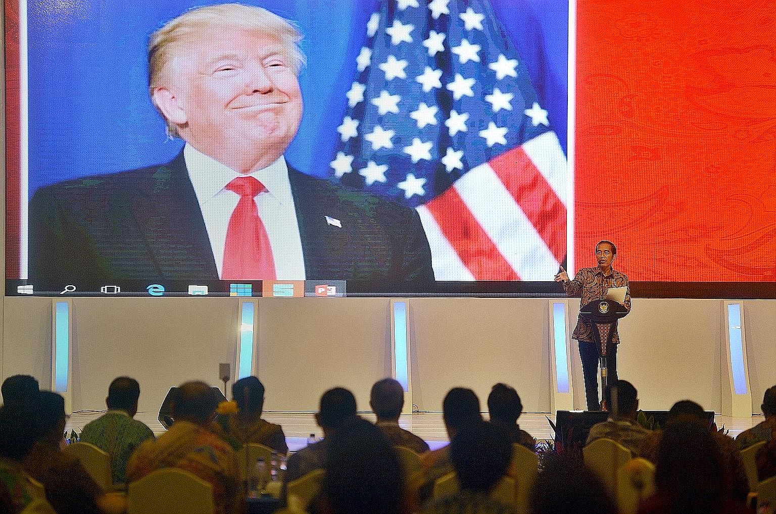 Indonesian President Joko speaking to local company executives as a picture of Mr Trump is shown on the screen behind him at the Kompas CEO forum in Jakarta last November. According to the writer, Mr Joko, like the incoming US president, is a product