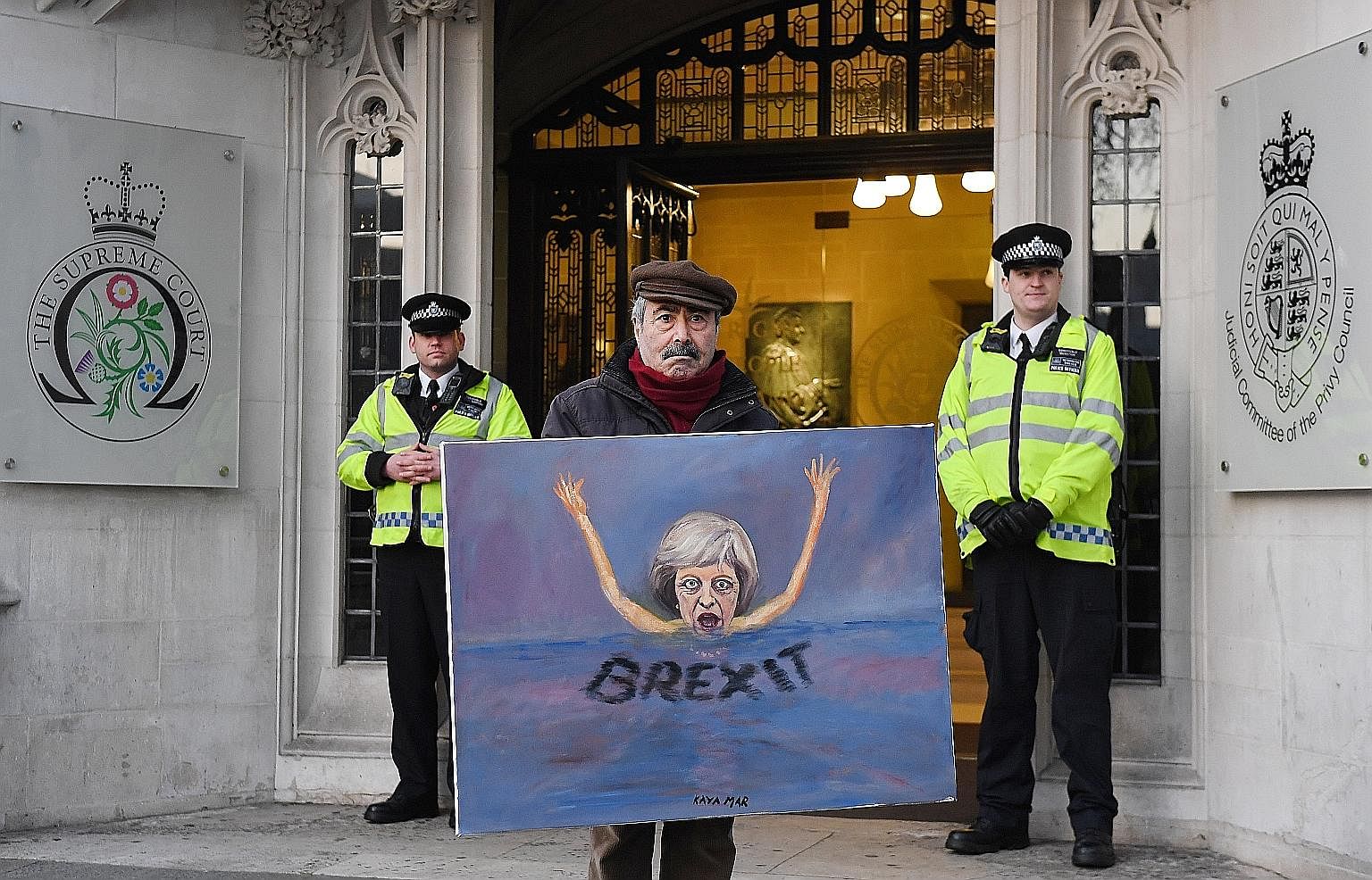 Political satire artist Kaya Mar with a painting depicting British PM Theresa May outside the Supreme Court in London, on Tuesday. What the court has done in this case is no different to what it does every day: It decided on what it considers to be t