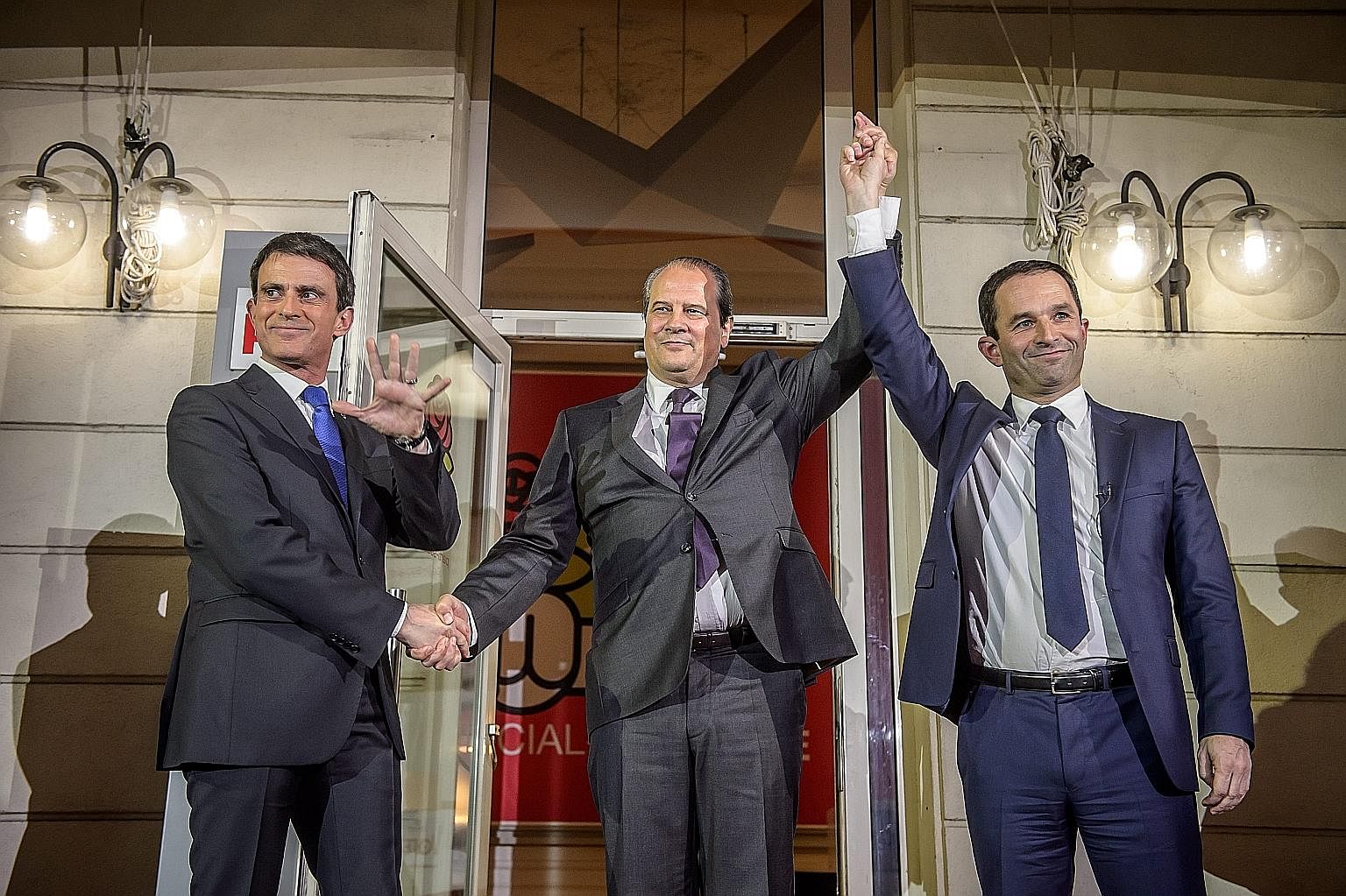 French Socialist party secretary Jean-Christophe Cambadelis (centre) flanked by Mr Benoit Hamon (far right), the winner of the second round of the party's primaries for the 2017 presidential election, and his opponent Manuel Valls on Sunday.