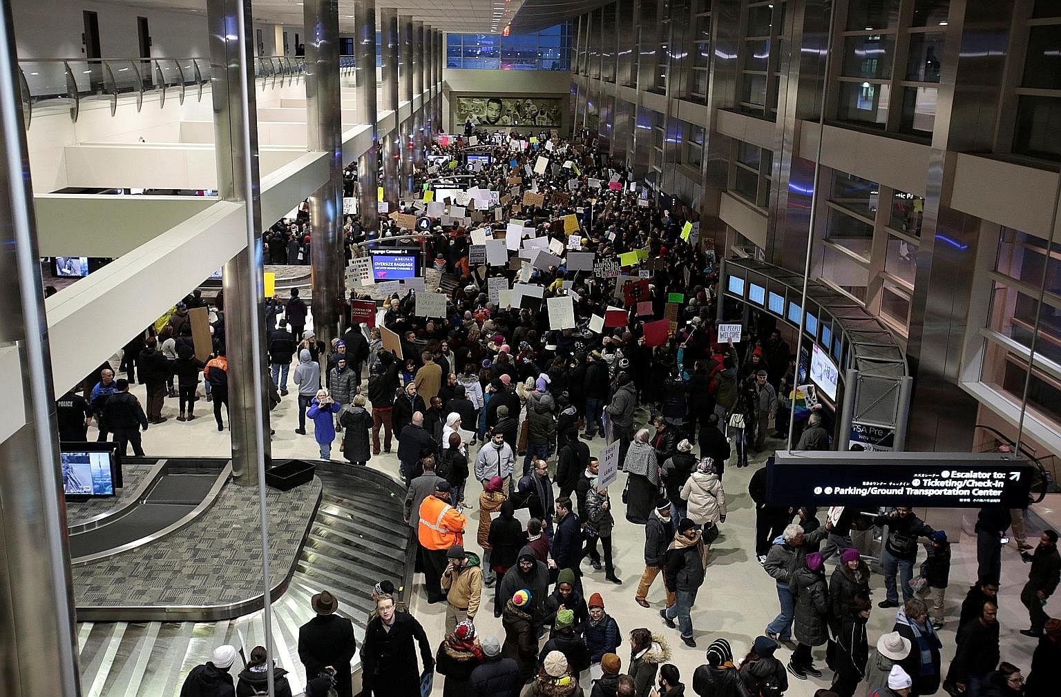 Volunteer lawyers setting up camp at Chicago's O'Hare Airport on Sunday to help immigrant travellers and their families after Mr Trump issued an executive order on immigration. Protesters gathering at the baggage claim area of Detroit Metropolitan Ai
