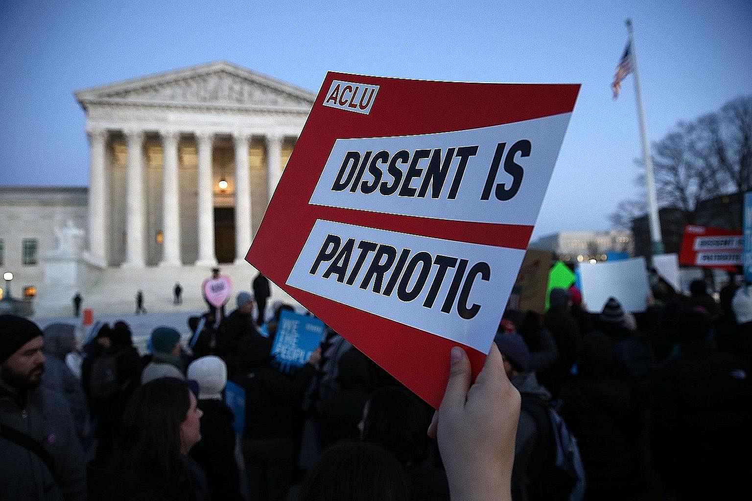 Protesters demonstrating outside the Supreme Court on Monday against US President Donald Trump's recent executive order that suspends the processing of all visa applications for people from seven Muslim-majority nations and temporarily halts America'