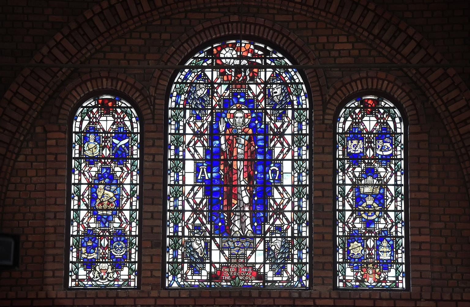 Stained glass windows bearing the image of Christ and the badges of the various regiments and forces that fought for the British in Malaya and Singapore.