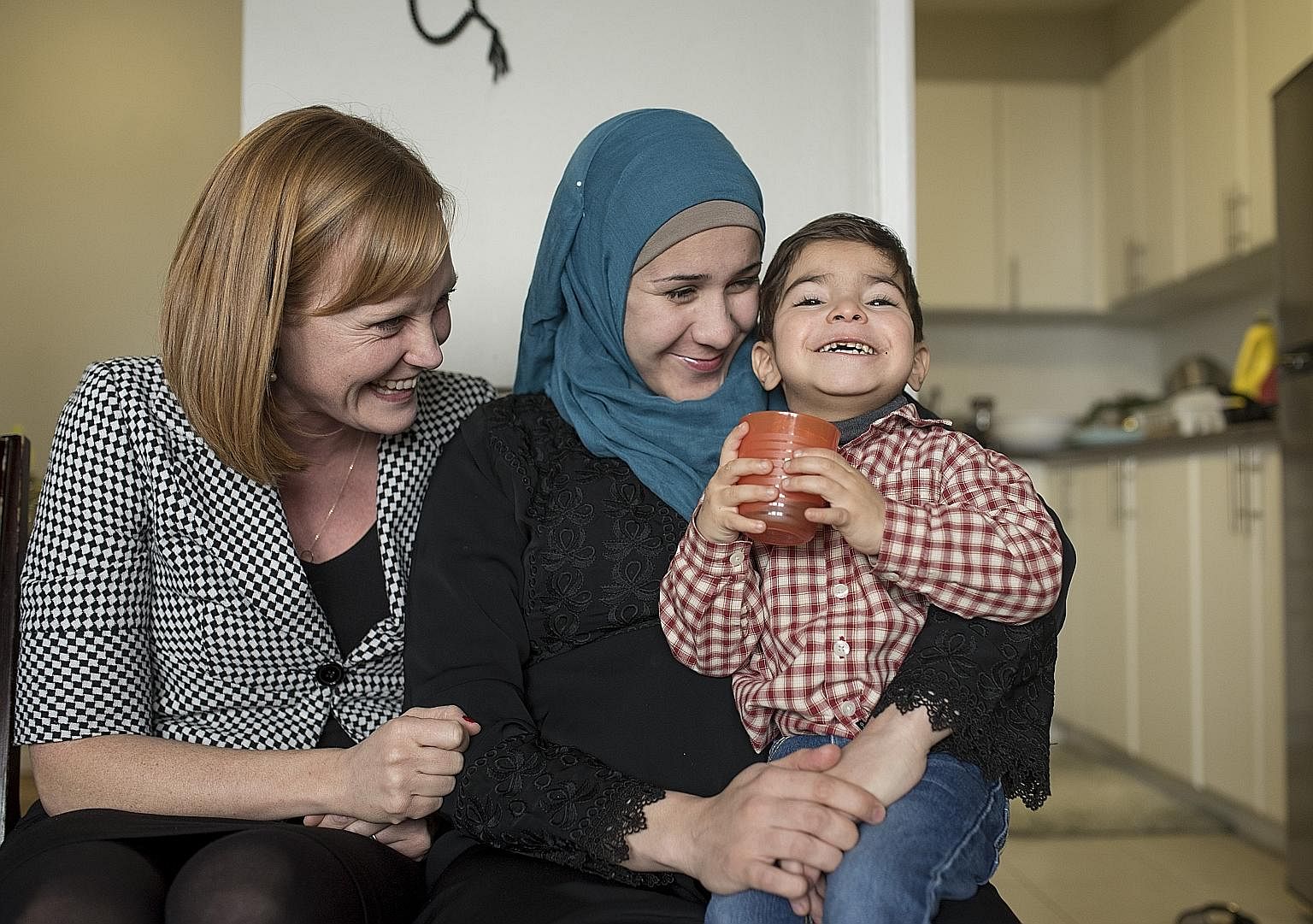 Ms Jessie Thomson, who has sponsored a family of Syrian refugees, with Ms Asmaa Alkrad and her son Taim, three, in Ottawa, Ontario, last week. Canada has a system of citizen sponsorship where five or more people can form a group to help newcomers int