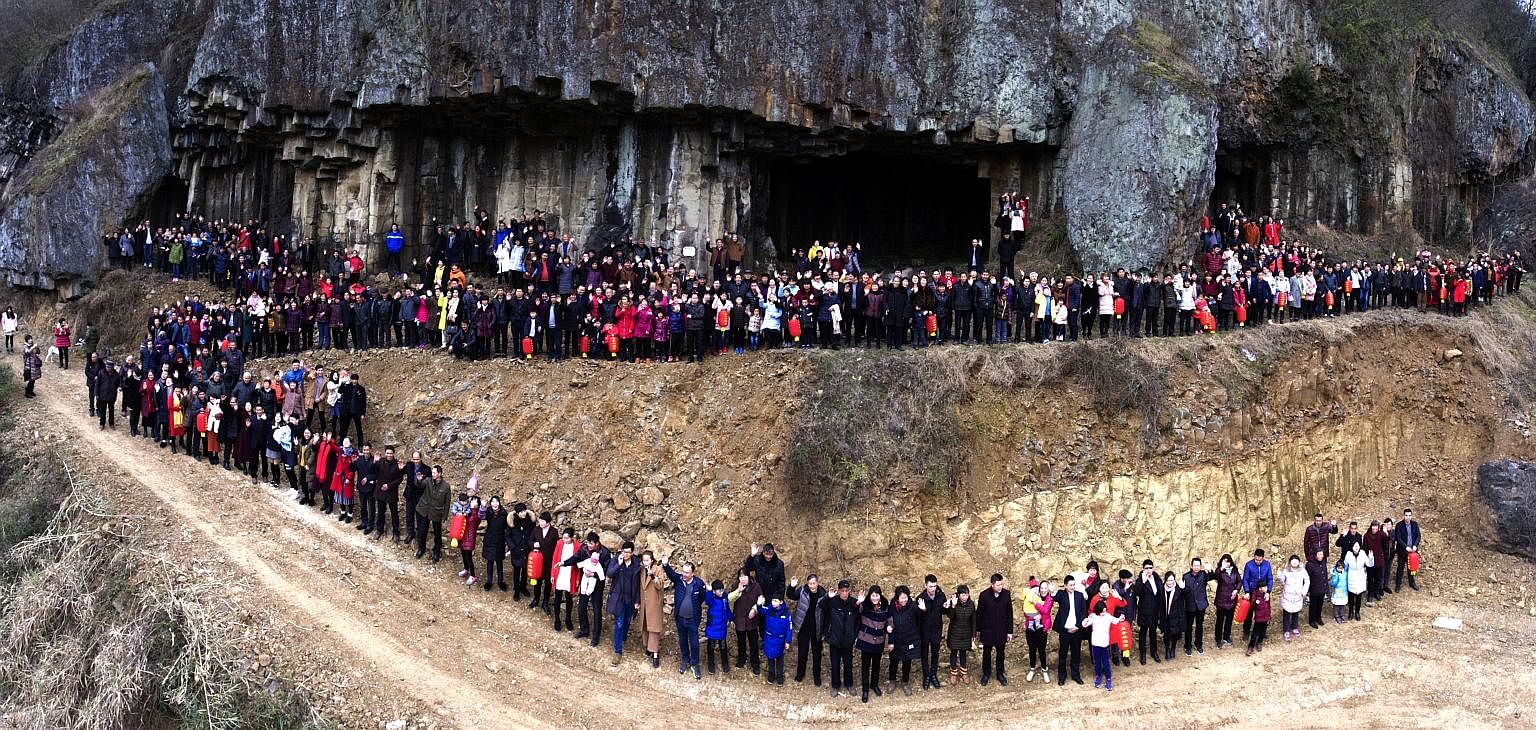 The group, made up of seven living generations of the Ren family, are pictured standing in front of a cliff at Shishe village in China's Zhejiang province. They had travelled from places such as Beijing, Shanghai, Xinjiang and Taiwan, brought togethe