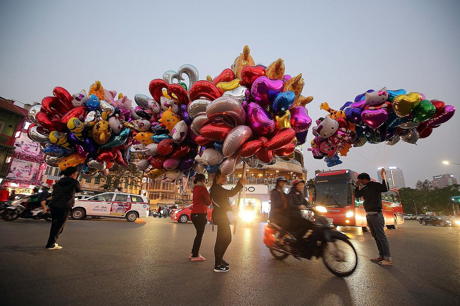 VIETNAM: People selling colourful balloons on a street in Hanoi on Monday. Valentine's Day has become very popular in Vietnam in recent years, as a way to express love, especially among teenagers. CAMBODIA: A blood donor taking a selfie at the Nation