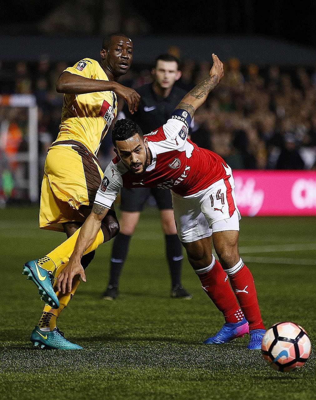Arsenal forward Theo Walcott fighting with Sutton midfielder Bedsente Gomis for the ball. He scored his 100th goal for the Gunners when he netted in the 55th minute.
