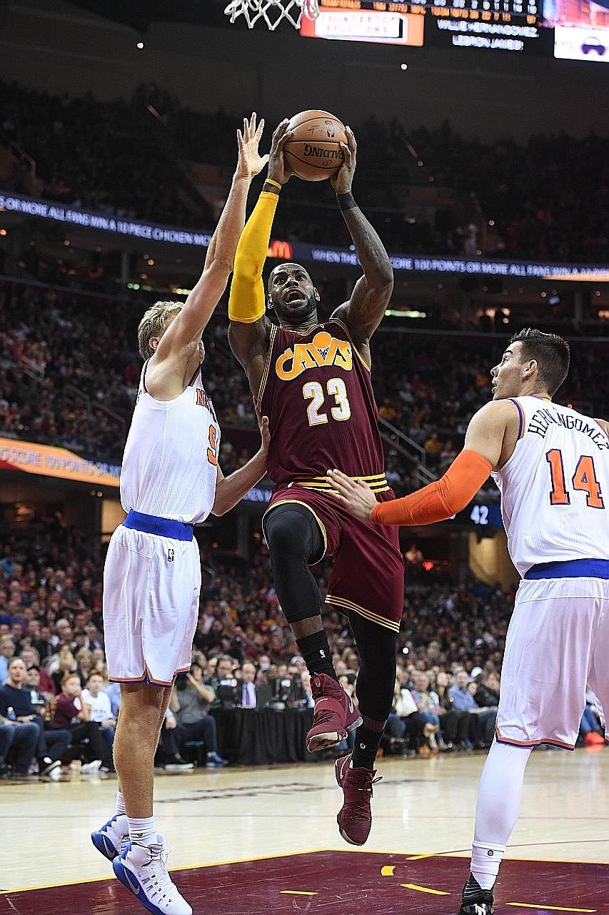 LeBron James shoots between Mindaugas Kuzminskas (left) and Willy Hernangomez of the New York Knicks. Despite a 119-104 win, the Cavaliers were chastised for a lacklustre period in the third quarter.