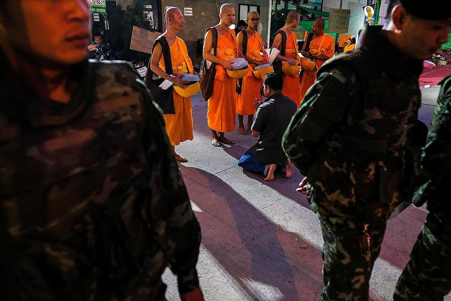 Monks receiving food from supporters. Amid a manhunt being carried out under the junta's wide-ranging powers, the temple has staged an international media campaign and alleged that its food supply has been curtailed.
