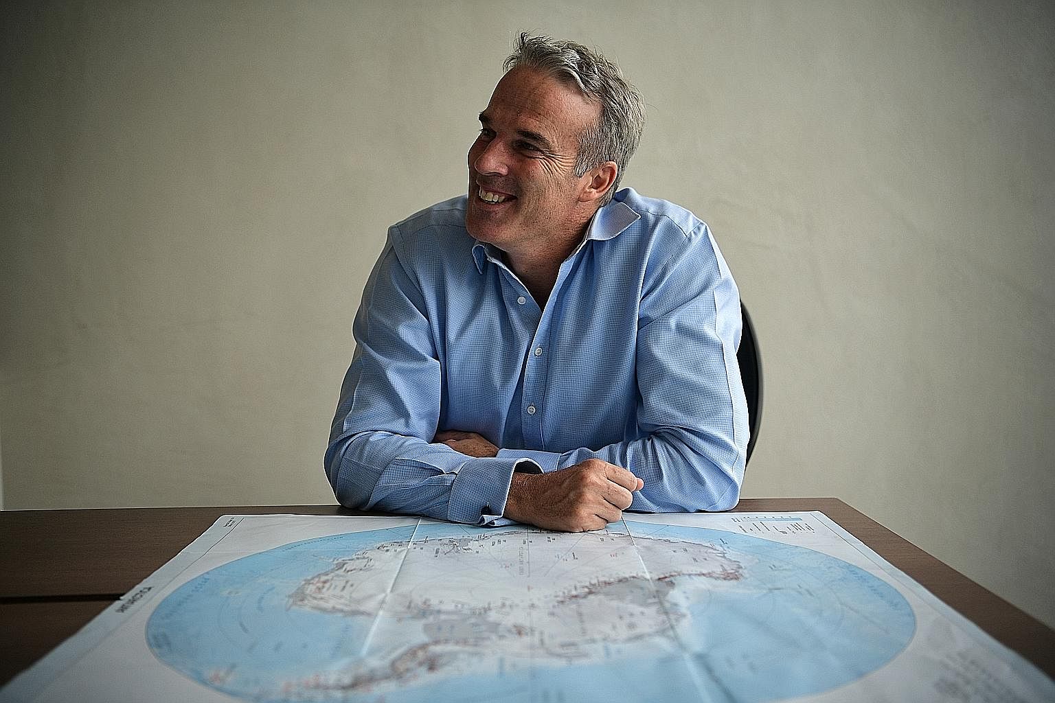 Mr Pugh with a map of Antarctica (above), where he is trying to create seven marine protected areas by 2020. He is often asked to give talks, such as this one about the oceans with children in the Maldives.