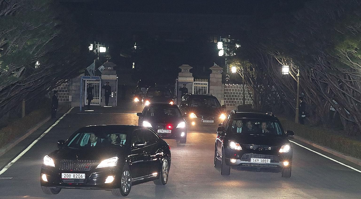 South Korea's impeached president Park Geun Hye (in car at left) being driven away from the presidential Blue House as she returned to her private residence in Seoul on Sunday, two days after the Constitutional Court's verdict confirming her removal 