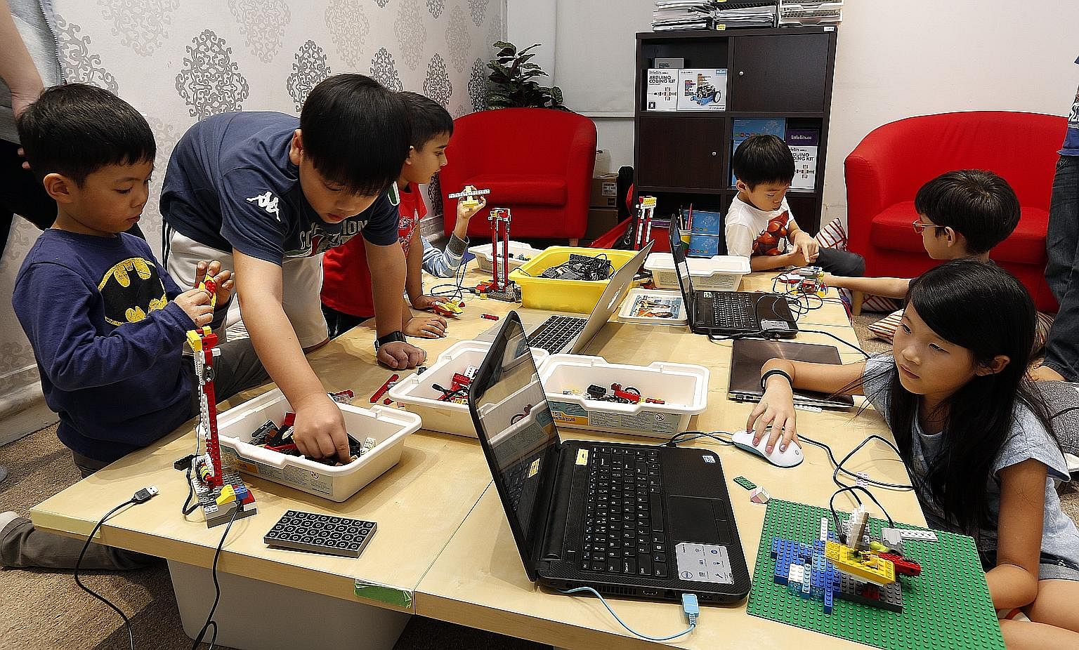 Children learning how to make their own robots using Lego pieces during a holiday workshop on robotics and game design at In3Labs. Robots and computer programs are helping do jobs ranging from delivering room service to providing financial advice, an